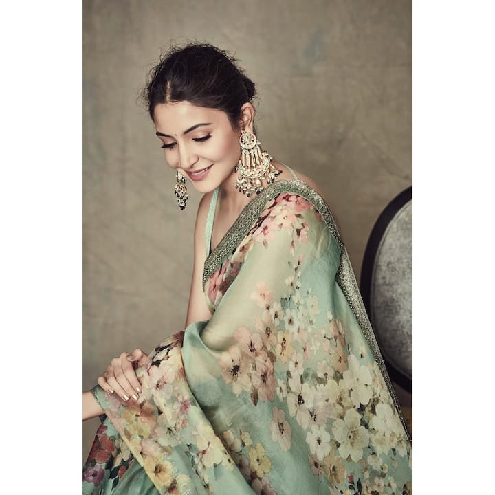 This Karva Chauth hairstyle of Anushka Sharma is allagant. He has tied his hair to Messi Low Ban. Loose braids are left near the forehead that are softly frameing the face, and bringing a slight volume in the blow. This style is fully highlighting their light floral saris and statement earrings, giving a graceful look.