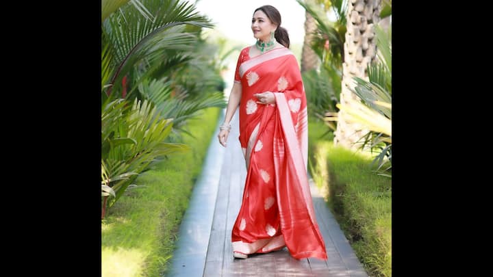 2. Madhuri Dixit: Madhuri Dixit proves yet again why she’s the ultimate saree icon as she dazzles in a silk red saree with golden motifs, perfect for Karwa Chauth 2025. The glossy fabric radiates festive charm, while the subtle zari detailing elevates its timeless elegance. Paired with a matching blouse, silver bangles, and a striking emerald choker, her look beautifully balances sophistication with tradition. For women looking for a graceful yet statement-making Karwa Chauth red saree, Madhuri’s style is the ultimate inspiration. (Image Source: Instagram/@madhuridixitnene)