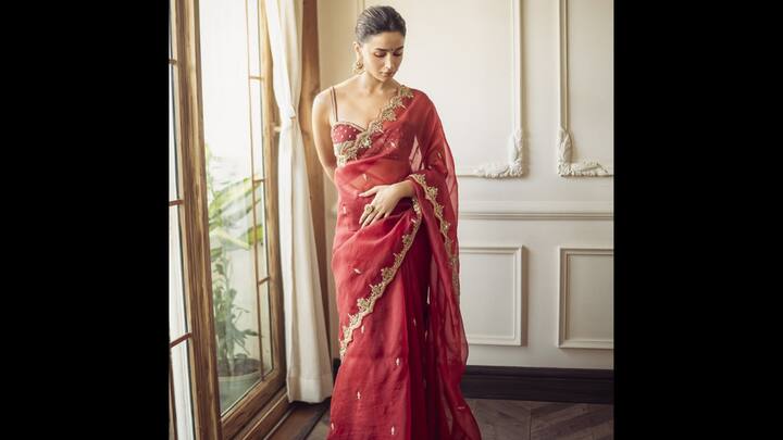 8. Alia Bhatt: This Sindoori Red Organza Saree worn by Alia Bhatt is the perfect inspiration of Karwa Chauth 2025. The six yards of grace are a beautiful sindoor red in sheer silk fabric. The vibrant red colour is traditionally auspicious and perfectly suited for Karwa Chauth. The minimal yet rich detailing is a major highlight. The saree features delicate hand adda work, intricate gold sequins embellishments, and zardozi work along the scalloped borders. The gold work on the rich red provides the perfect festive shine without being overly heavy. She paired the saree with a matching red silk blouse that elevates the contemporary-traditional fusion. The organza fabric and the contemporary strappy blouse keep the look light and chic, while the traditional colour and gold zardozi work root it firmly in festive elegance. (Image Source: Instagram/@toraniofficial)