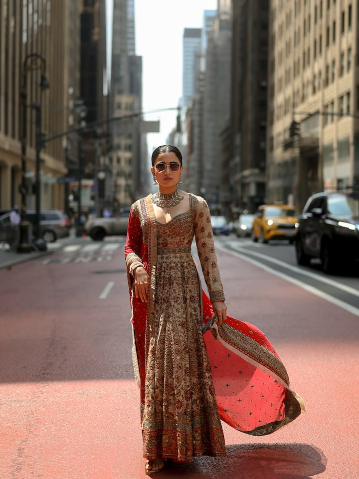 Rashmika is in a very luxurious and traditional look in this picture, which she has carried the road to New York City. He is wearing a light cream -colored full sleeves Anarkali suit, on which fine embroidery work has been done. Along with this Anarkali, he has taken a red and pink colored scarf, which has a border and work of Zari. Along with heavy silver oxidized Choker necklace and matching earrings, his desi look is also showing Indian culture in the international environment.