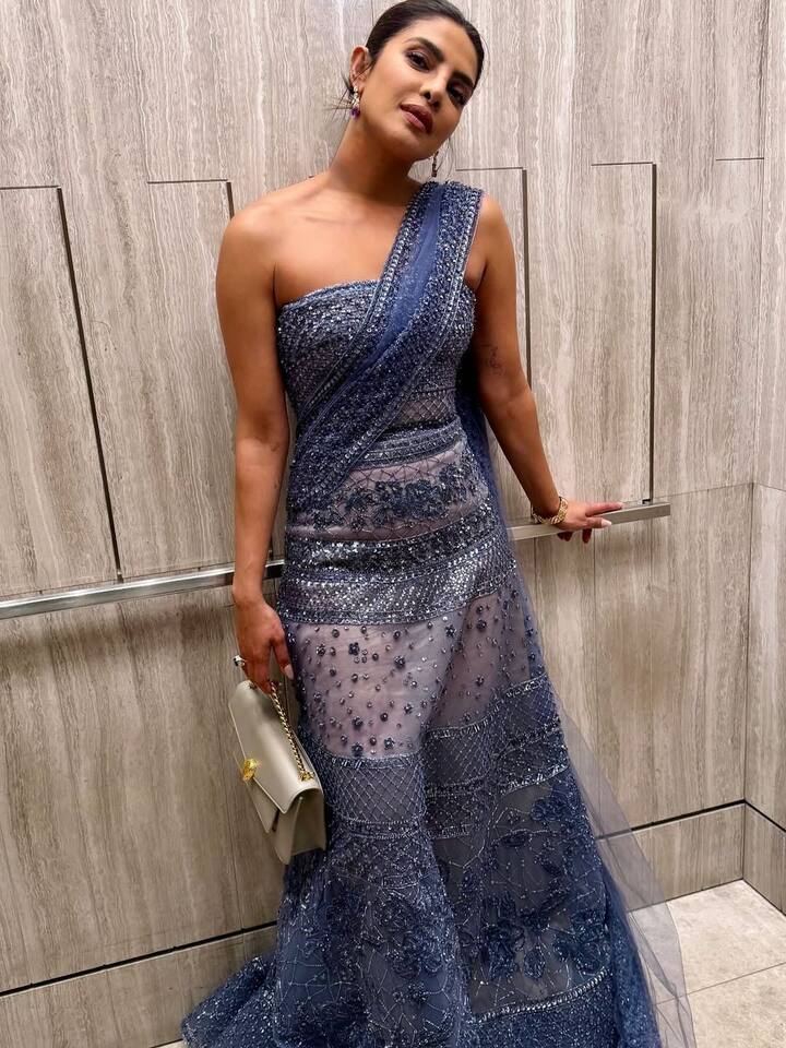 For this event, Priyanka chose Elli Saab's cobalt blue and nude color gown. It was styled by Indian celebrity stylist Ami Patel. This gown with a strapless silver was making her look bold and elegant. This included fitted bodis, low square neckline, cured waste, Floi Marmeid-style skirt and tulle overlay.