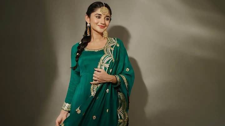 In this bottle green Anarkali, Kanika strikes the perfect festive balance. The outfit features delicate golden mirror and thread work at the neckline, paired with a richly embroidered dupatta, a beautiful choice for newlywed brides celebrating their first Karwa Chauth. (Image Source: Instagram/ officialkanikamann)