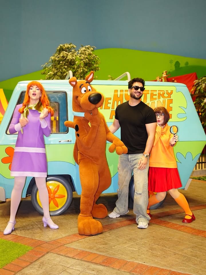 One picture shows him posing with Scooby-Doo characters and the iconic machine van.