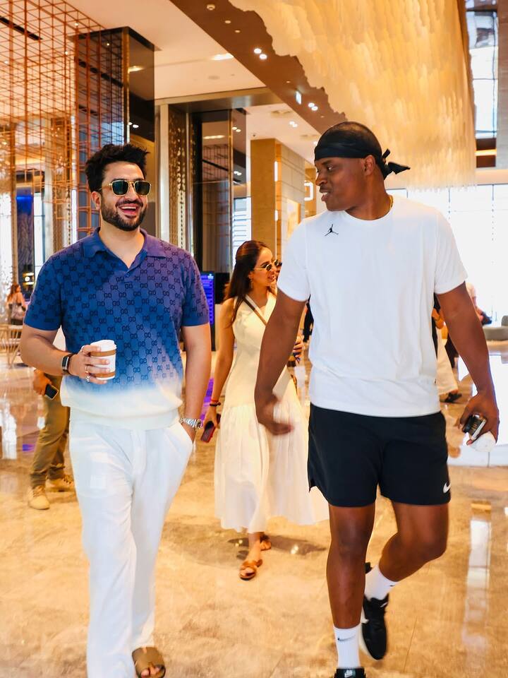 Another snapshot features Aly strolling through a warmly lit lobby.