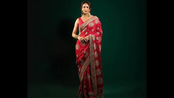 8. ⁠Classic Red Banarasi Saree: Rakul Preet has once again set hearts aflutter with her breathtaking red Banarasi sari look. The actress looked resplendent in a rich crimson-red sari adorned with intricate golden zari motifs and heavy embroidery. Her ethnic outfit exuded royal charm and festive opulence. The traditional weave, paired with a sleeveless blouse and matching tones, elevated her look into a modern-day fantasy. She styled the outfit with traditional temple jewellery, statement earrings, and gold bangles, letting her radiant beauty and poise do the talking. (Image Source: Instagram/@rakulpreet)