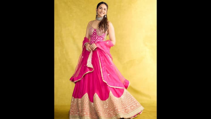 3. Vibrant Pink Lehenga: Rakul Preet Singh set major festive fashion goals in a radiant fuchsia pink lehenga. Her outfit beautifully captures the essence of Indian celebrations. The vibrant hue, combined with intricate embroidery and golden detailing, makes this ensemble a true showstopper. The actress looked ethereal in a heavily embroidered pink lehenga skirt paired with a floral embellished blouse featuring delicate gold threadwork. The ensemble was completed with a sheer organza dupatta, edged with a golden border that added the perfect festive shimmer. (Image Source: Instagram/@rakulpreet)