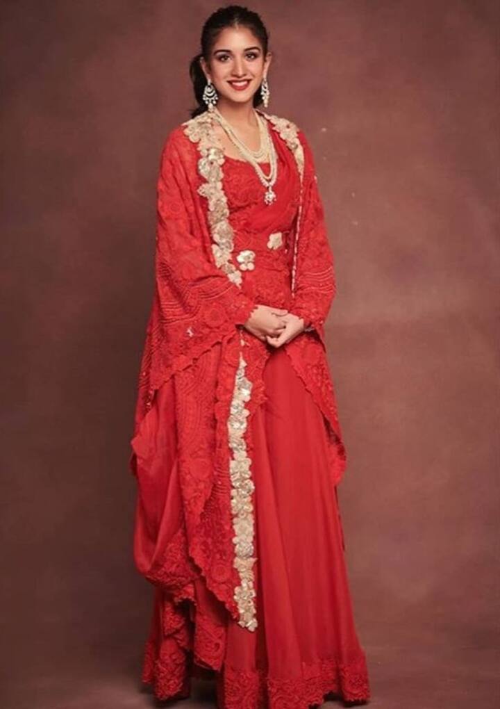 If you want to look royal as well as modern on Diwali, then you can wear a red colored designer outfit like Radhika Merchant. You can give a royal touch to your look with a pearl necklace.