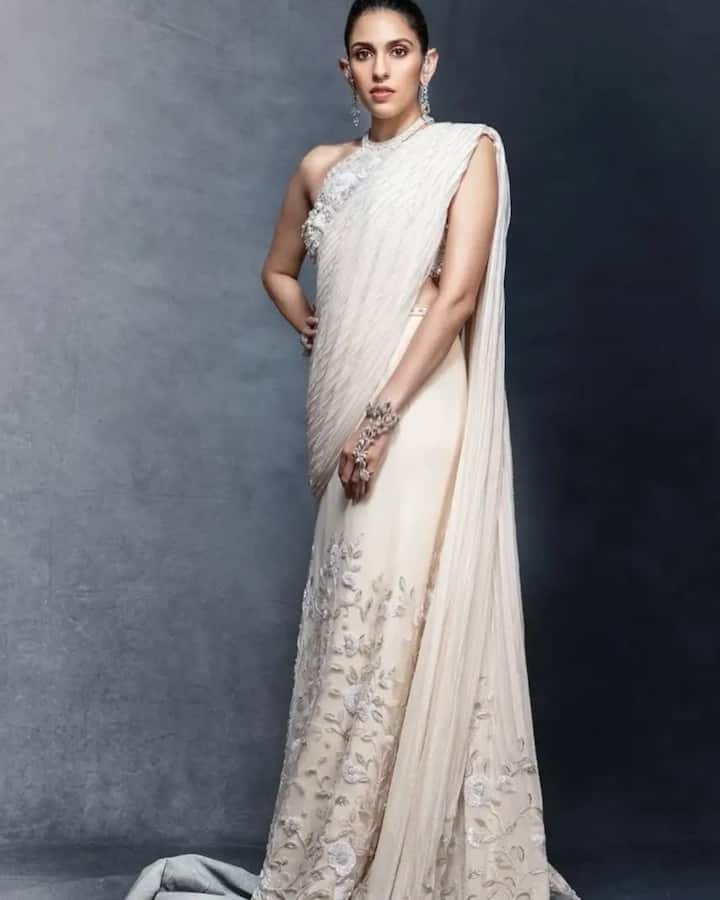 You can pair halter neck blouse with white color saree. You can complete your look with bun hairstyle and matching earrings.
