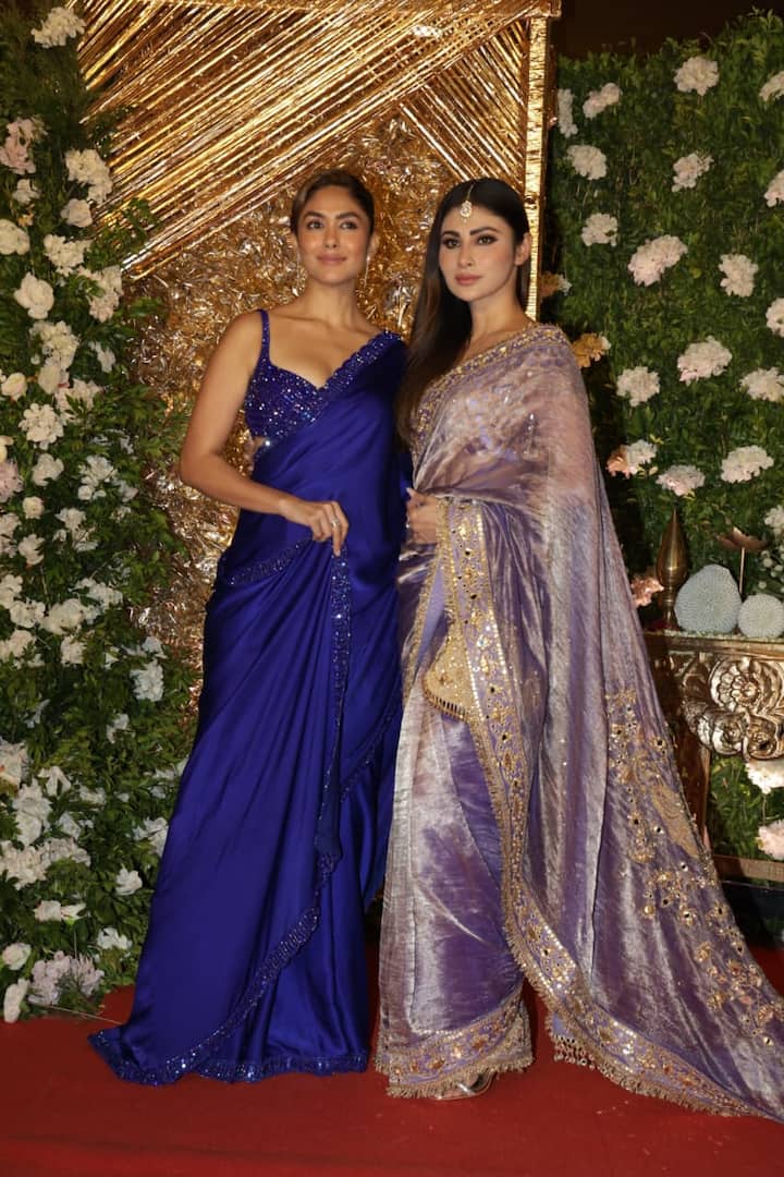 Mrunal Thakur chose a royal blue colored satin plain saree. She paired it with a deep-neck sleeveless blouse studded with sequins and pearls, adding a tinge of glamor to the look.