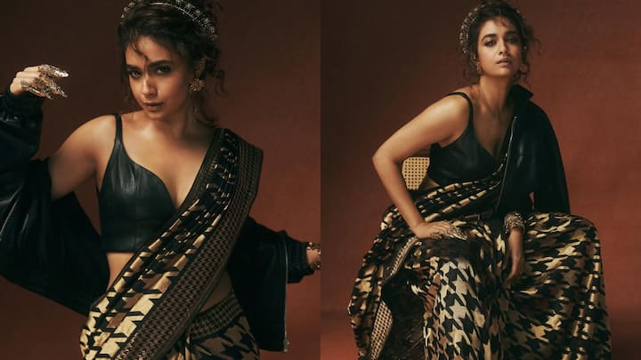 3. Bold Leather Blouse Look: Keerthy Suresh takes a daring detour from traditional festive wear with this sleek black leather blouse, proving that sarees can be as edgy as they are elegant. The structured V-neck blouse, with its minimalist straps and sharp tailoring, instantly adds a modern, high-fashion edge to her metallic saree. Paired with a black bomber jacket and statement accessories, this look blurs the lines between couture and classic. (Image Source: Instagram/@primevideoin)