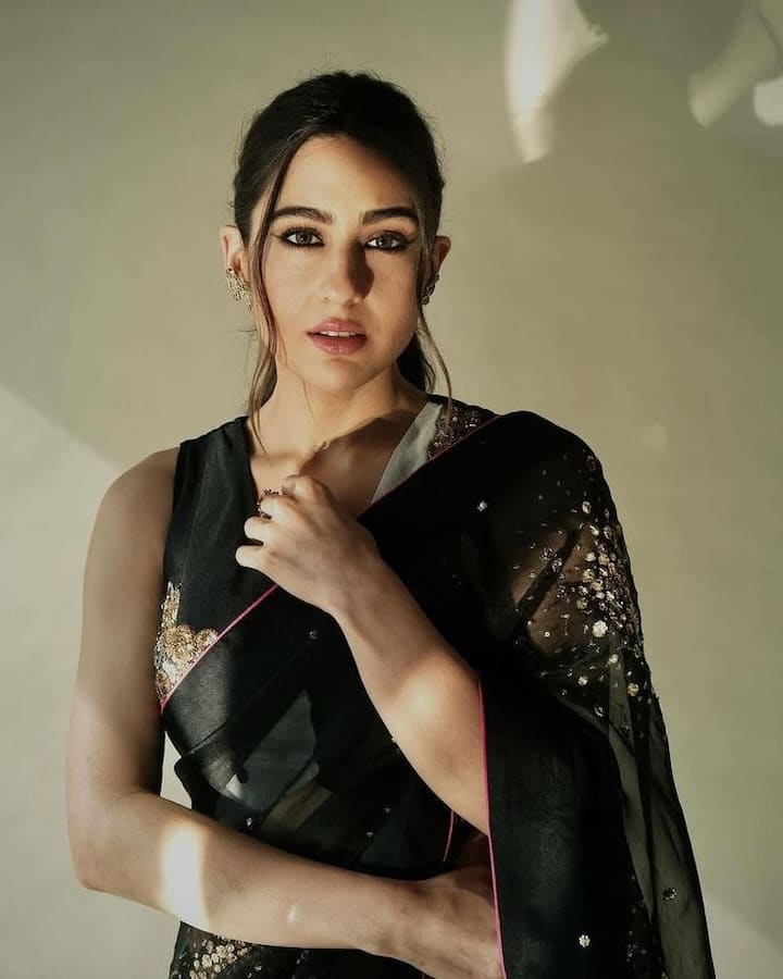 From Lehengas To Sarees: Sara Ali Khan’s Best Ethnic Looks To Ace The Festive Season Saree Soirée Goals: Make a statement this Diwali in a black georgette saree like Sara Ali Khan’s. With intricate golden embellishments, a V-neck blouse, a sleek ponytail, and soft glam makeup, it’s the perfect choice for an elegant yet bold festive soirée.