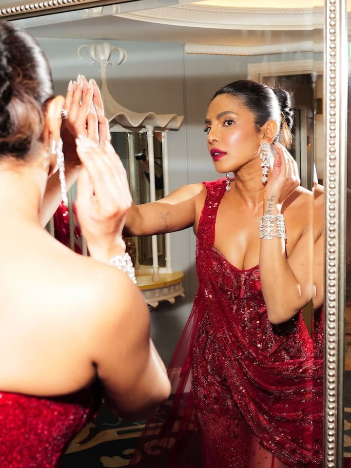 Eschewing traditional festive golds and silvers, Priyanka made a statement in a one-shoulder red gown featuring a corset-style bodice adorned with sequins and intricate beadwork that perfectly highlighted her figure.