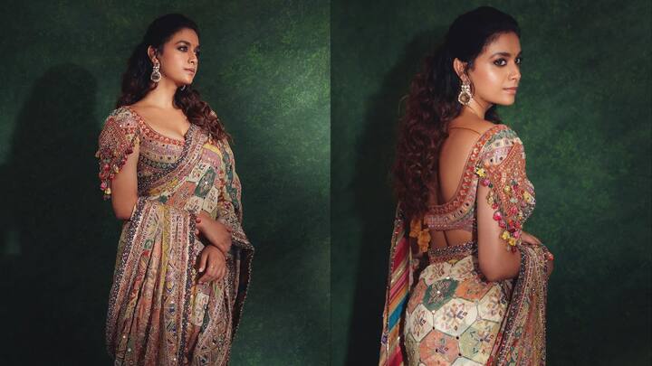 5. Heavily Embellished Dreamy Blouse: This blouse, rich in traditional craftsmanship and colourful detailing, is a vibrant mix of Gujarati-inspired embroidery, mirror embellishments, and playful tassel sleeves. The blouse features intricate mirror work paired with fine thread embroidery across a rich multicoloured fabric base. The sleeves steal the show with their eye-catching tassels and pom-pom details, giving the overall look a fun, youthful vibe. Another striking feature is the deep scoop back design, which adds a bold and sensual flair to the otherwise traditional blouse. (Image Source: Instagram/@keerthysureshofficial)