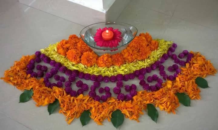 इस बार की दिवाली पर अगर आप पर्यावरण के साथ सुंदरता भी जोड़ना चाहते हैं, तो फूलों के रंग की होली बना सकते हैं. गंदे, गुलाब और चमेली के फूलों से बनी ये रंगोली घर में प्राकृतिक खुशबू और सुकून दोनों फैलाती है. गोल आकार या मोर और कमल जैसे पारंपरिक डिजाइन में फूल की पंखुड़ियां लगाकर आप इस दिवाली मेहमानों का स्वागत खास अंदाज में कर सकते हैं.