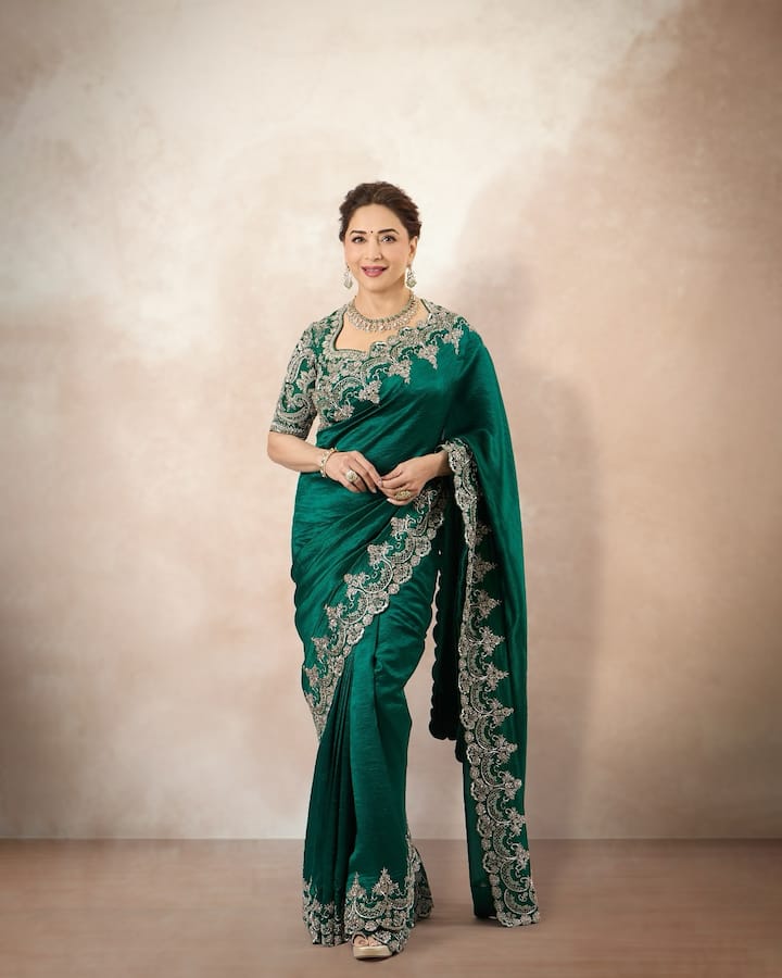 Madhuri is wearing emerald green colored saree in this look. There is fine silver colored embroidery on the saree and its matching blouse. The silver embroidery work on this color looks very different and classy. She paired her look with polki stone jewelery like a choker necklace and matching earrings. If you want a traditional heavy embroidered look with brilliant colors on Bhai Dooj, then this emerald green saree will give you a different look.
