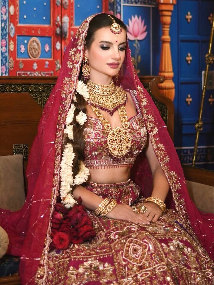 वायरल तस्वीरों में नतालिया जानोसजेक दुल्हन के लाल जोड़े में नजर आ रही हैं. लाल रंग की ये लहंगा चोली उनपर काफी जच रहा है और फैंस भी उनका ऐसा अवतार देख अपनी नजरें हटा नहीं पा रहे हैं. माथे पर हसीना ने डिजाइनर दुपट्टा भी सजाया है जो उनके इस लुक को रॉयल टच दे रहा है.