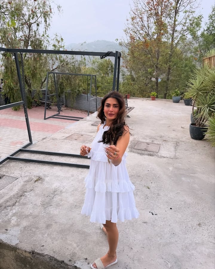 पवित्रा का यह लुक एक बेहद कंफर्टेबल और समर-फ्रेंडली है. उन्होंने सफेद रंग की हॉल्टर नेक फ्रिल ड्रेस पहनी है, इसमें कई लेयर में फ्रिल हैं. यह ड्रेस उन्हें एक ब्रीज़ी लुक दे रही है. इस कैज़ुअल आउटफिट को उन्होंने सिल्वर रंग की फ्लैट चप्पल और पैरों में एंक्लेट के साथ स्टाइल किया है. खुले बाल इस कंफर्टेबल आउटडोर लुक को पूरा कर रहा है.