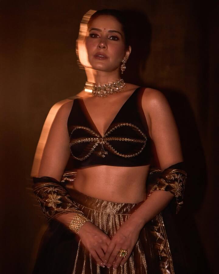 Paired with a rich gold metallic lehenga skirt featuring textured sheen and fluid movement, the ensemble stands out for its timeless grandeur. Draped lightly over her arms, the matching embroidered stole enhances the royal undertones of the look without overpowering it.