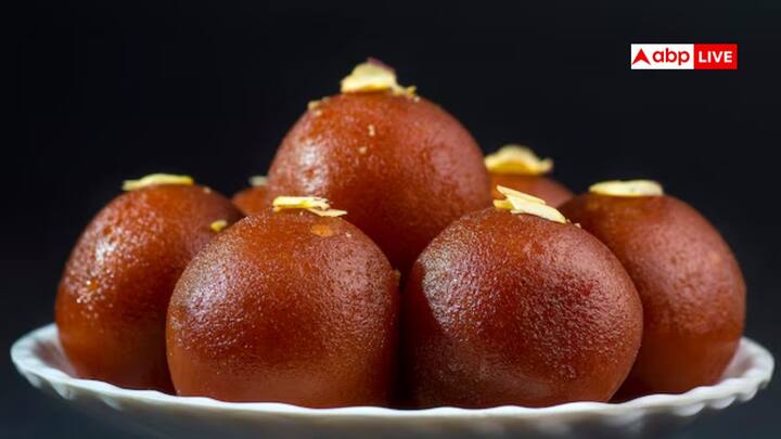 Gulab Jamun Name: गुलाब जामुन ऐसी मिठाई है, जिसे शायद ही किसी ने न खाया हो. लेकिन इसमें न तो गुलाब है और न ही जामुन, फिर भी इस मिठाई का नाम और इतिहास दोनों ही बेहद दिलचस्प हैं.