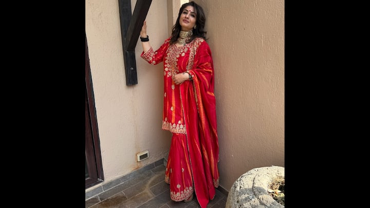 4. Festive Glamour In Red Embroidered Sharara Set: Raveena Tandon lights up the festive mood in a breathtaking red sharara set that’s all things regal and radiant. The outfit features intricate gold embroidery on the kurta and hemline, paired with a beautifully woven dupatta that enhances its rich, traditional charm. Styled with a statement choker, kohl-rimmed eyes, and a striking red bindi, Raveena balances elegance with nostalgia. Her look captures the essence of classic Indian glamour while remaining effortlessly modern. (Image Source: Instagram/@officialraveenatandon)