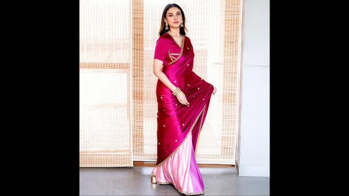 4. खूबसूरत मैजेंटा और गुलाबी सिल्क साड़ी: अदिति राव हैदरी एक जीवंत मैजेंटा सिल्क साड़ी में सूक्ष्म सोने की कढ़ाई और एक विपरीत ओम्ब्रे गुलाबी रंग की शानदार सुंदरता का प्रतीक हैं। समृद्ध बनावट और निर्दोष कपड़ा उसकी शाश्वत सुंदरता को उजागर करता है, जबकि गहरे गले का ब्लाउज आधुनिक आकर्षण का संकेत देता है। उत्सव के अवसरों या शादियों के लिए बिल्कुल उपयुक्त, यह लुक सादे ग्लैमर के साथ मिश्रित पारंपरिक भारतीय परिष्कार के सार को दर्शाता है। उनका लुक स्टेटमेंट झुमके, स्टैक्ड चूड़ियों और मिनिमल मेकअप के साथ पूरा हुआ है। यह खूबसूरत पहनावा उन लोगों के लिए एक आदर्श प्रेरणा है जो क्लासिक रेशम और परिष्कृत विवरण के साथ अपने उत्सव के परिधान को ऊंचा करना चाहते हैं। (छवि स्रोत: इंस्टाग्राम/@अदितिरावहिदरी)