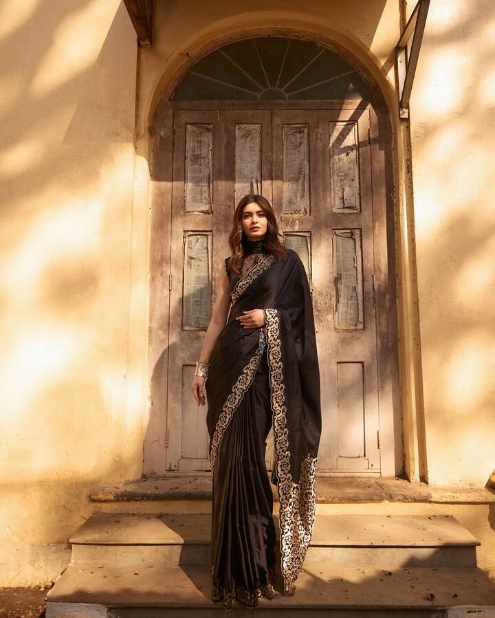 Diana is looking royal and elegant in this look. She is wearing a black saree on which beautiful golden border work has been done. The sleeveless blouse and minimal jewelery with the saree has made her look even more classy. Open wavy hair and subtle makeup are adding grace and sophistication to her entire look.