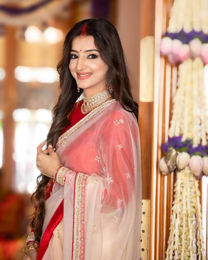 व्हाइट कलर की साड़ी को यहां लवलीन ने रेड ब्लाउज के साथ ड्रेप किया है. मांग में सिंदूर और माथे पर लाल बिंदी लगाकर वो किसी नई नवेली दुल्हन की तरह दिख रही हैं.