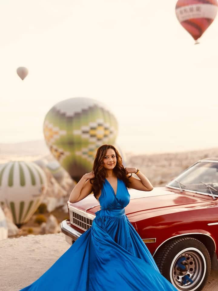 इस तस्वीर में मदालसा डार्क ब्लू रंग के लंबे गाउन में हैं. गाउन सैटिन का है, जिसमें डीप वी-नेक है और नीचे बहुत बड़ा फ्लेयर है. उन्होंने बहुत कम ज्वेलरी पहनी है और बाल खुले रखे हैं. मेकअप सॉफ्ट और नैचुरल है.