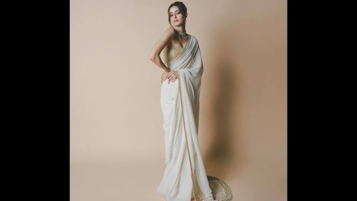 5. आइवरी गोल्ड साड़ी: अनन्या पांडे ने चमकदार सोने के ब्लाउज के साथ एक क्लासिक आइवरी साड़ी पहनी थी, जिससे एक ऐसा लुक तैयार हुआ जो भव्यता के साथ अतिसूक्ष्मवाद को पूरी तरह से मिश्रित करता है। नरम, लहराते पर्दे को सूक्ष्म सोने की सीमा द्वारा उभारा गया है, जो उत्सव की चमक का सही स्पर्श जोड़ता है। उनका संरचित, सेक्विन्ड कॉर्सेट ब्लाउज पारंपरिक साड़ी को एक बोल्ड और आधुनिक मोड़ देता है, जिससे पहनावा सहजता से ग्लैमरस बन जाता है। (छवि स्रोत: इंस्टाग्राम/@ananyapanday)