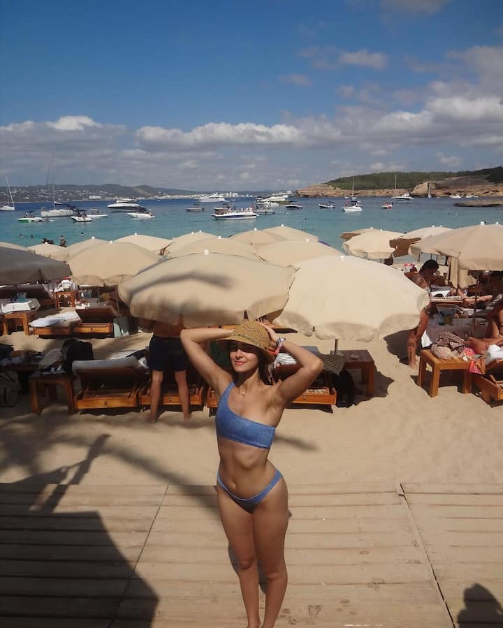 In this look, Ananya is wearing a blue one-shoulder bikini. She has completed her beach look with a straw hat, which she is holding with her hands. This look is chill, stylish and perfect for the ocean.