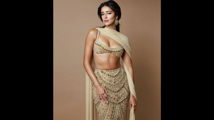 2. गोल्ड हेवीली बीडेड फिट: अनन्या पांडे ने मनीष मल्होत्रा ​​की इस सोने से सजी पोशाक में सबका ध्यान अपनी ओर आकर्षित किया, जो एक आधुनिक मोड़ के साथ उत्सव के ग्लैमर को फिर से परिभाषित करता है। लुक में विलासिता झलकती है - भारी सेक्विन, क्रिस्टल-जड़ित ब्लाउज से लेकर जटिल हाथ से कढ़ाई की गई पोशाक तक। संरचित ब्रैलेट ब्लाउज एक समकालीन बढ़त जोड़ता है। स्टेटमेंट गोल्ड इयररिंग्स, बोल्ड कॉकटेल रिंग और मिनिमम ड्रेप के साथ स्टाइल किया गया यह फिट उत्सव और शादी के मौसम के लिए आदर्श है। (छवि स्रोत: इंस्टाग्राम/@ananyapanday)