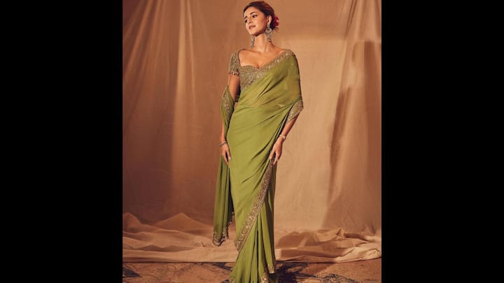 3. ⁠कालातीत हरी साड़ी: अनन्या पांडे इस जैतून-हरे रंग की साड़ी में शुद्ध पुरानी दुनिया का आकर्षण दिखाती हैं जो कि शालीन लालित्य का प्रतीक है। ड्रेप में बॉर्डर के साथ नाजुक सेक्विन और ज़री की कढ़ाई है, जो पहनावे की न्यूनतम अपील पर हावी हुए बिना एक राजसी चमक पैदा करती है। छोटी अलंकृत आस्तीन वाला गहरा स्वीटहार्ट नेकलाइन ब्लाउज ग्लैमर का एक सुंदर स्पर्श जोड़ता है। साड़ी का मटमैला रंग उनकी चमकती त्वचा के रंग को खूबसूरती से पूरा करता है, जिससे यह उनका सबसे खूबसूरत एथनिक लुक बन जाता है। (छवि स्रोत: इंस्टाग्राम/@ananyapanday)