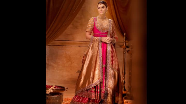 7. कृति सैनन: कृति सैनन ने एक लुभावनी विरासत से प्रेरित पहनावे में उत्सव की भव्यता को फिर से परिभाषित किया। तांबे की टोन वाले ब्रोकेड दुपट्टे के साथ फ्यूशिया गुलाबी अनारकली पहने कृति के लुक ने समकालीन वस्त्र शिल्प कौशल का जश्न मनाते हुए भारत के कालातीत शाही सौंदर्यशास्त्र को श्रद्धांजलि अर्पित की। पोशाक में जटिल जरदोज़ी कढ़ाई, नाजुक सेक्विन विवरण और समृद्ध बनारसी बनावट शामिल थी, प्रत्येक तत्व समृद्धि और पुरानी यादों को दर्शाता था। (छवि स्रोत: इंस्टाग्राम/@kritisanon)