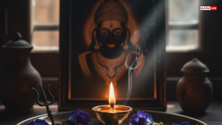 सरसों के तेल का दीपक जलाएं और उसे शनिदेव के चित्र या प्रतीक के पास रखें. मान्‍यता है क‍ि घर में शन‍िदेव की मूर्ति नहीं रखनी चाह‍िए. पूजा में काले तिल, लोहे की वस्तुएँ और फूल चढ़ाएं। चाहें तो शनिदेव को पंचामृत से स्नान भी करा सकते हैं.