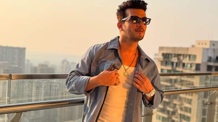 Arjun nails urban cool in this light blue overshirt layered over a white tank and paired with cargo jeans. Accessories like a pendant chain and sunglasses add streetwear charm to this easygoing outfit. (Image Source: Instagram/ arjunbijlani)