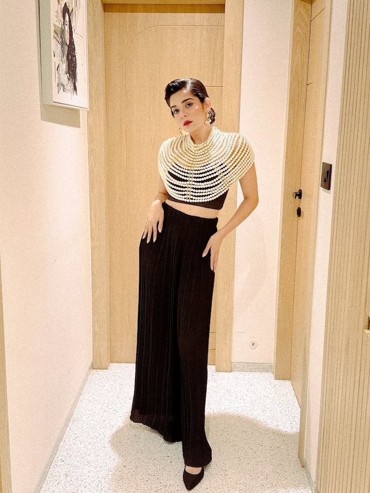 या पोस्टमध्ये तिने ब्लॅक कलरचा ग्लॅमरस ड्रेस घातला आहे आणि त्यावर मोत्याची बॉडी-चेन परिधान केली आहे.