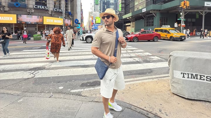 Arjun embraces travel comfort with this beige tee and white printed shorts, complemented by white sneakers and a monogram sling bag. The look is perfect for city strolls or relaxed sightseeing days. (Image Source: Instagram/ arjunbijlani)