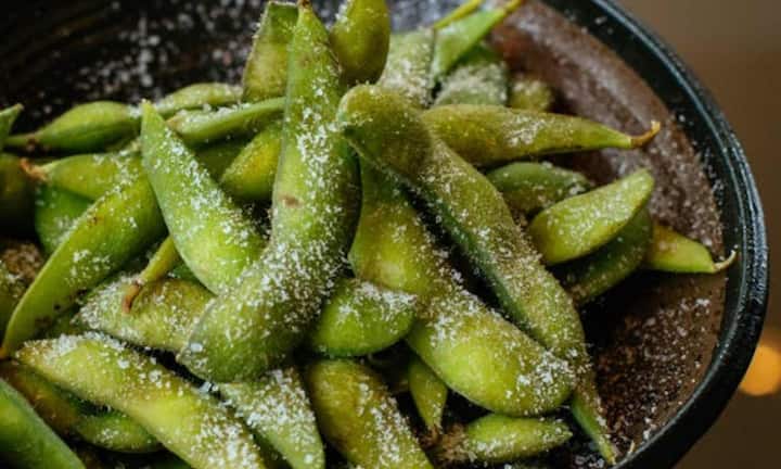 3. एडामे – सोयाबीन का एक प्राकृतिक रूप – एडामे, जो कि कच्चा सोयाबीन होता है, में आइसोफ्लेवोन्स नामक पादप-आधारित यौगिक होते हैं। ये यौगिक शरीर में एस्ट्रोजन रिसेप्टर्स पर सकारात्मक प्रभाव डालते हैं। शोध बताते हैं कि आइसोफ्लेवोन्स स्तन और प्रोस्टेट कैंसर के जोखिम को कम करने में मदद कर सकते हैं। इसके अलावा, एडामे में फाइबर और प्रोटीन दोनों की मौजूदगी पाचन में सुधार करती है और वजन प्रबंधन में भी सहायक होती है।