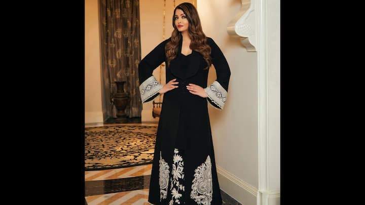 7. Royal Elegance In Black Embroidered Ensemble: The outfit, featuring exquisite floral and paisley motifs, beautifully combines traditional craftsmanship with modern sophistication. The statement flared sleeves with intricate beadwork add a touch of drama to the minimalist silhouette, while Aishwarya’s soft curls, bold red lips, and effortless poise elevate the entire look into a masterclass of understated glamour. (Image Source: Instagram/@aishwaryaraibachchan_arb)