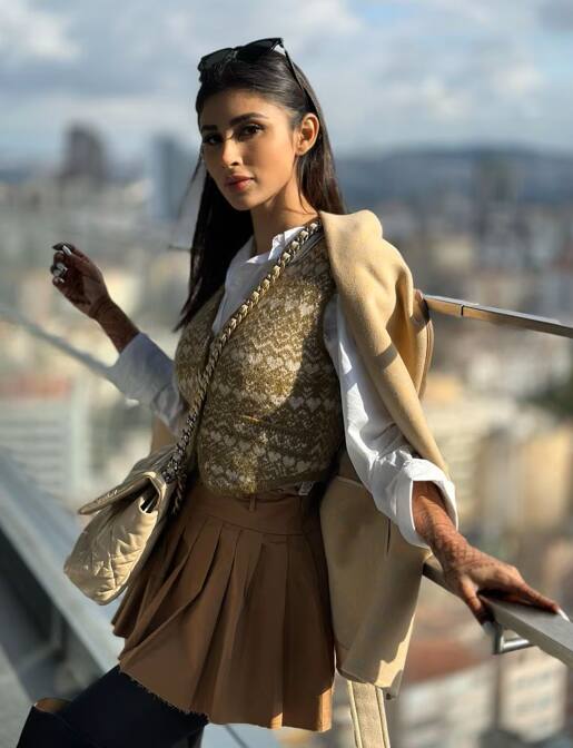 This look of Mouni Roy is perfect for the winter season. She has worn half sweater and stockings with mini skirt and shirt, which is making her look modern.