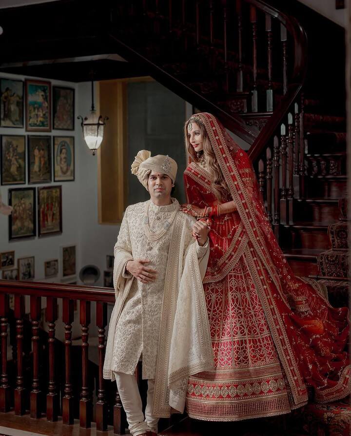 अपनी शादी में मशहूर बिजनेसमैन वेदांत बिड़ला ऑफ वाइट कलर की शेरवानी में नजर आएं. उनके जिस वेडिंग आउटफिट में बारीक कारीगरी की गई है जो उनके इस लुक को और भी एन्हांस कर रहा है. इसके साथ ही उन्होंने वाइट पर्ल नेकपीस को अपने आउटफिट के साथ पेयर किया. कंट्रास्टिंग कलर के साफे के साथ दूल्हे राजा ने अपना लुक कंप्लीट किया.