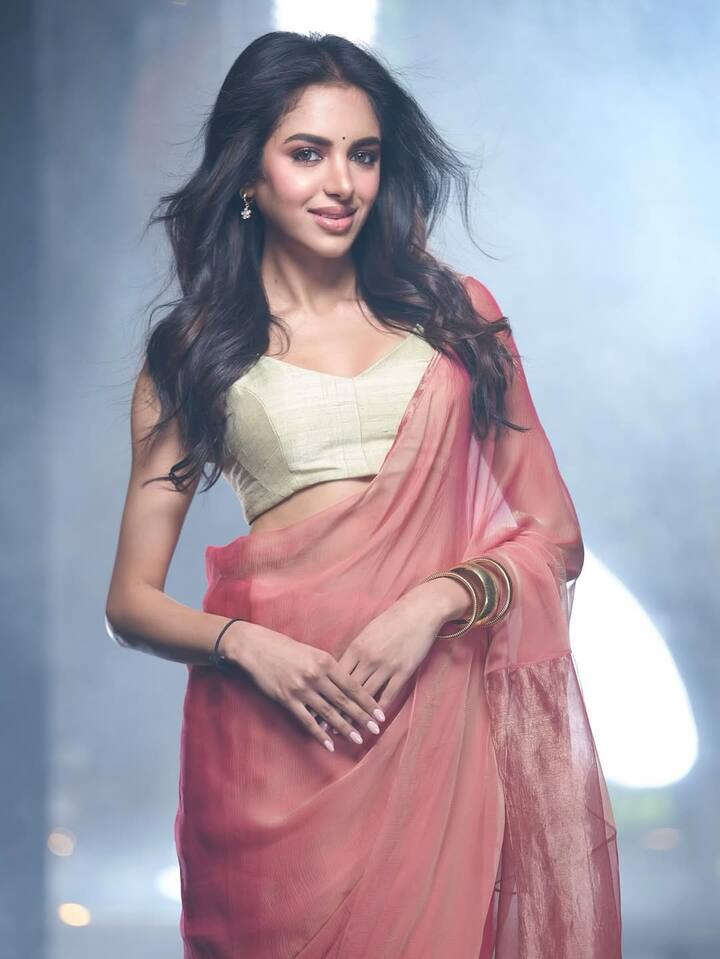 पीच कलर की साड़ी को किआ ने ऑफ व्हाइट ब्लाउज के साथ ड्रेप किया है. गोल्डन चूड़ियां, माथे पर काली बिंदी और ओपन हेयरस्टाइल उनके लुक को क्लासी बना रहे हैं.