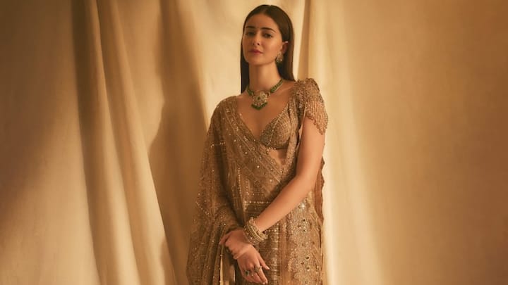 Ananya Panday dazzles in this golden saree that fuses traditional artistry with modern allure. The sheer, embellished drape adorned with sequins and beadwork radiates soft glamour, while her emerald jewellery adds a pop of colour, making the look festive yet refined. (Image Source: Instagram/ taruntahiliani)