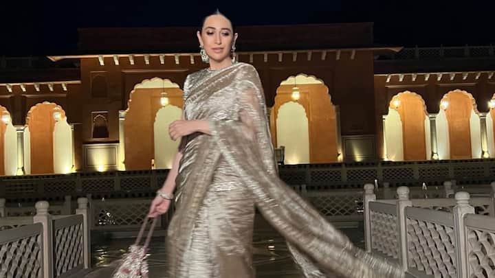 Karisma Kapoor dazzles in this shimmering golden saree adorned with intricate sequin and threadwork, exuding regal sophistication. She pairs it with emerald jewellery, a sleek bun, and soft glam makeup, creating a timeless blend of elegance and charm. (Image Source: Instagram/ therealkarismakapoor)