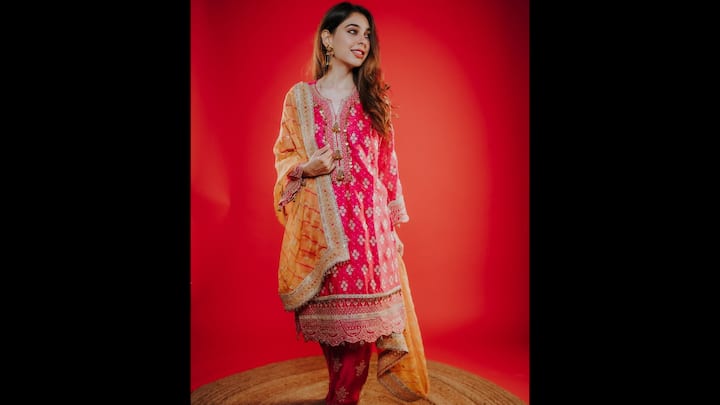 1. Vibrant Pink Ethnic Ensemble: This outfit of the actress is a masterclass in blending bold colour with timeless elegance. Niti stuns in a bright pink embroidered kurta adorned with golden motifs and delicate threadwork. The outfit is beautifully complemented by a contrasting mustard-yellow dupatta with embellished borders that add a regal touch to the ensemble. Her choice of statement jhumkas and minimal makeup keeps the focus on the vivid hues and detailed craftsmanship of her attire. (Image Source: Instagram/@nititaylor)