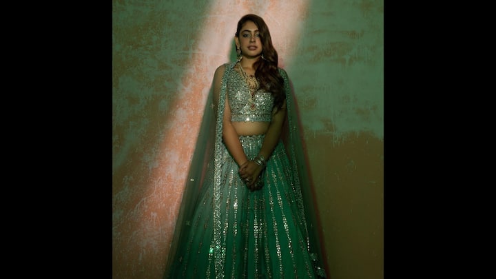 6. Dazzling Mirror-Work Lehenga: This look is a breathtaking blend of traditional charm and modern glamour. Dressed in a stunning emerald green lehenga adorned with intricate mirror work, she exudes regal grace with a hint of contemporary sophistication. The richly embellished blouse with a sweetheart neckline perfectly complements the flowy, shimmering skirt, creating a look that’s both festive and fashion-forward. Her sheer dupatta, delicately draped over the shoulders, adds a dreamy touch to the ensemble, while her choice of statement jewellery and soft curls enhances the ethereal vibe. This outfit is perfect inspiration for weddings, sangeet nights, or grand festive celebrations where tradition meets sparkle. (Image Source: Instagram/@nititaylor)