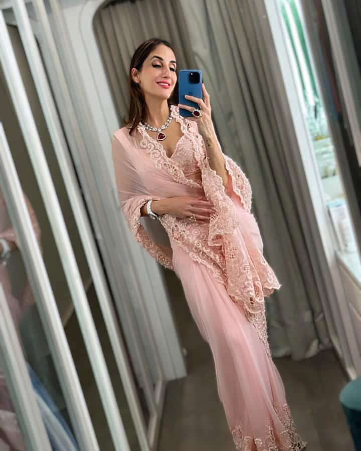 Desi look also suits Farah very well. She is looking very beautiful wearing a pink colored saree with matching jewellery.
