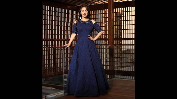 4. Navy Blue Cold-Shoulder Gown: Juhi Chawla makes a striking impression in this stunning navy blue cold-shoulder gown that perfectly balances modern sophistication with timeless charm. The gown features intricate lace detailing and a flattering A-line silhouette that accentuates her figure with effortless grace. The subtle shimmer woven into the fabric adds a touch of glamour, making it an ideal pick for evening galas or red-carpet events. The cold-shoulder design lends a contemporary twist to the gown. Her minimal makeup and confident stance bring out her enduring beauty and elegance, making this look a masterclass in understated luxury. (Image Source: Instagram/@iamjuhichawla)