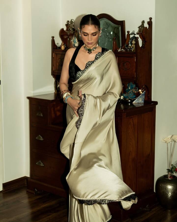 Aditi Rao Hydari wore Manish Malhotra's cream silk pearl saree for her special day. The border of the saree has black zari and pearl border which is making it even more beautiful. With this she has paired a black colored deep neck blouse, which enhances the look of her outfit.