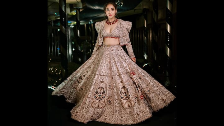 5. शाही अलंकृत लालित्य: नीति मोहन एक जटिल कढ़ाई वाले लहंगा सेट में कालातीत विलासिता बिखेरती हैं जो सीधे तौर पर एक आधुनिक शाही उत्सव जैसा लगता है। लहंगे में शानदार धागे की कारीगरी, सेक्विन और क्लासिक मुगल-प्रेरित रूपांकनों से सुसज्जित एक राजसी गोलाकार चमक है। प्रत्येक पैनल को सावधानीपूर्वक तैयार किया गया है, जो सममित पैटर्न, बनावट वाली कढ़ाई और बहु-टोन अलंकरण प्रदर्शित करता है। गहरी नेकलाइन आधुनिक ग्लैमर का स्पर्श लाती है, जबकि अलंकृत कढ़ाई लहंगे की भव्यता के साथ सहजता से जुड़ती है। (छवि स्रोत: इंस्टाग्राम/@नीतिमोहन18)
